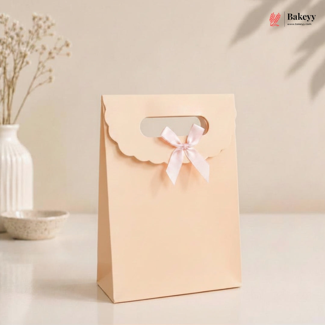 Beige gift bag with a pink ribbon on a light surface, featuring the Bakey brand.