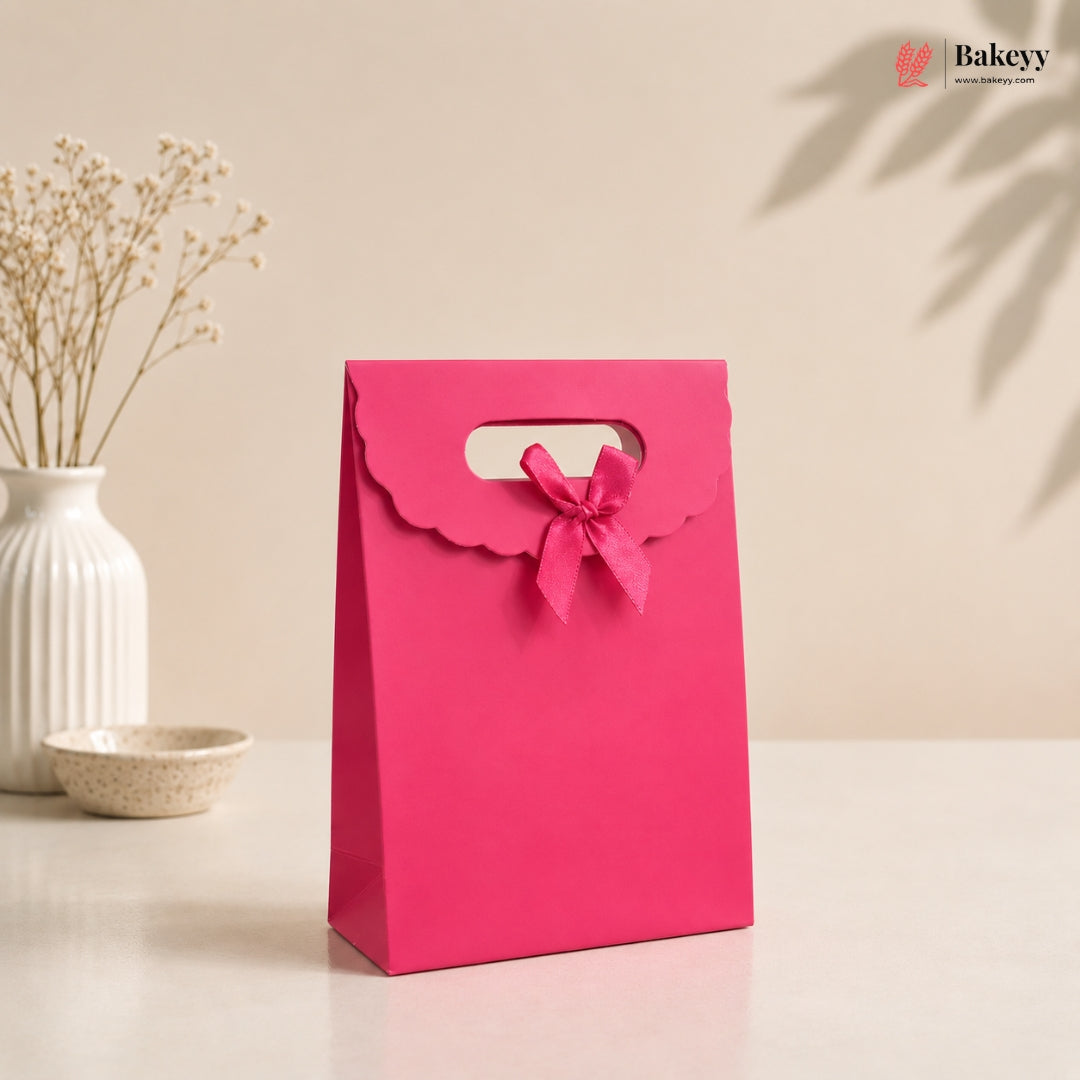 Pink gift bag with a bow on a beige background, featuring the brand 'Bakey'.