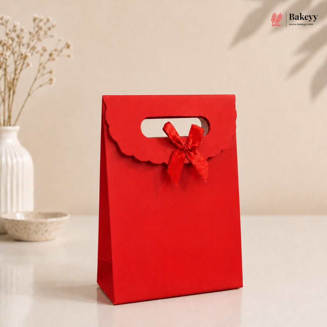 Red gift bag with a bow on a beige background, featuring the Bakey brand.