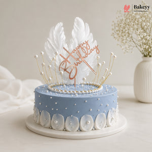 Decorative cake with feather topper and 'Happy Birthday' text on a light background