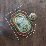 Decorative metal box with green and red embellishments on a wooden surface, showing measurements.