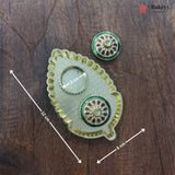 Decorative metal item with measurements on a wooden surface, featuring the brand 'Bakeyy'.
