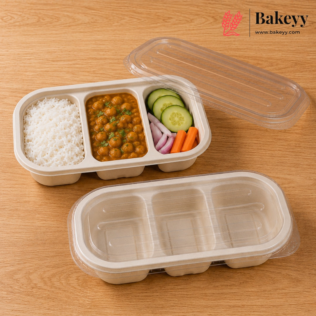 Two compartment plastic food containers with clear lids on a wooden tabletop. One container is open and filled with white rice, a curry with chickpeas, cucumber slices, red onion, and carrot sticks.