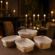 Set of brown cardboard food containers with lids on a dark background with candles.
