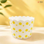 White cupcake liner with yellow polka dots on a yellow background