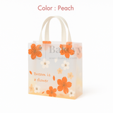 Peach-colored gift bag with floral designs and text on a white background