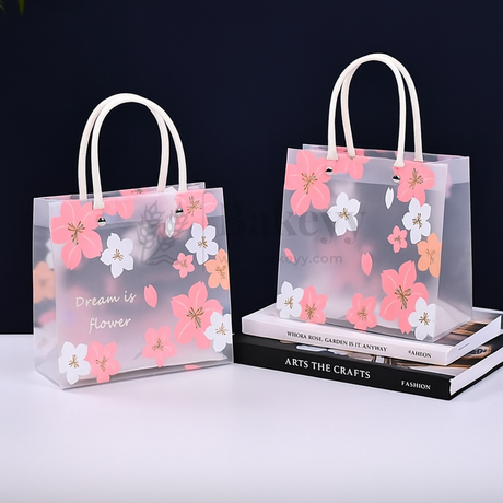 Transparent shopping bags with floral designs and white handles on a dark background.