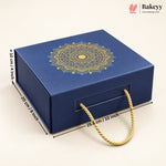 A dark blue square gift box with a gold mandala design on the lid and a gold rope handle, shown on a light beige background with dimension lines indicating 25.5 cm length, 10 cm height, and 20 cm width.