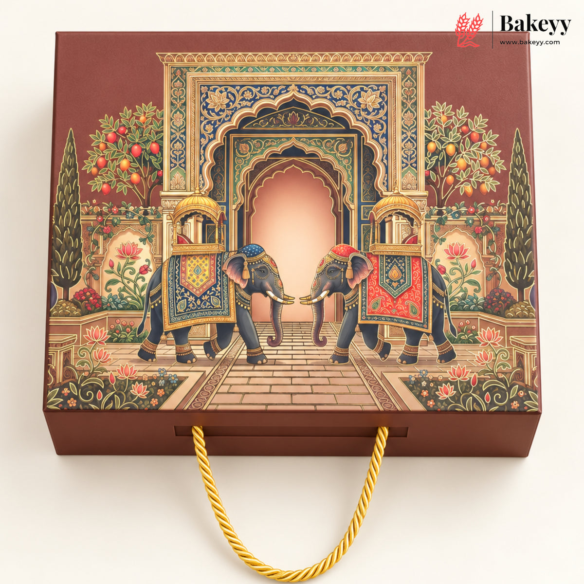 A rectangular brown gift box with a gold rope handle, decorated with an intricate traditional illustration of two decorated elephants under an ornate archway. The Bakeyy logo is visible in the top right corner.