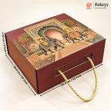 A rectangular bakery gift box with a decorative traditional-style illustration on the lid, featuring two elephants under an arch. The box is dark reddish brown with a gold rope handle and overlaid dimension lines showing measurements of 25.