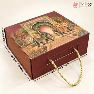 A rectangular bakery gift box with a decorative traditional-style illustration on the lid, featuring two elephants under an arch. The box is dark reddish brown with a gold rope handle and overlaid dimension lines showing measurements of 25.