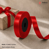A roll of bright red satin ribbon with a black center core, shown unspooled on a beige surface next to a brown gift box tied with the ribbon. Text at the bottom reads 'Width : 1/2 Inch / 1.