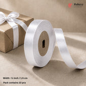 A roll of white satin ribbon with a length of ribbon unspooled, displayed next to a brown kraft paper gift box tied with a white ribbon. Text at the bottom indicates the ribbon is 1/2 inch (1.