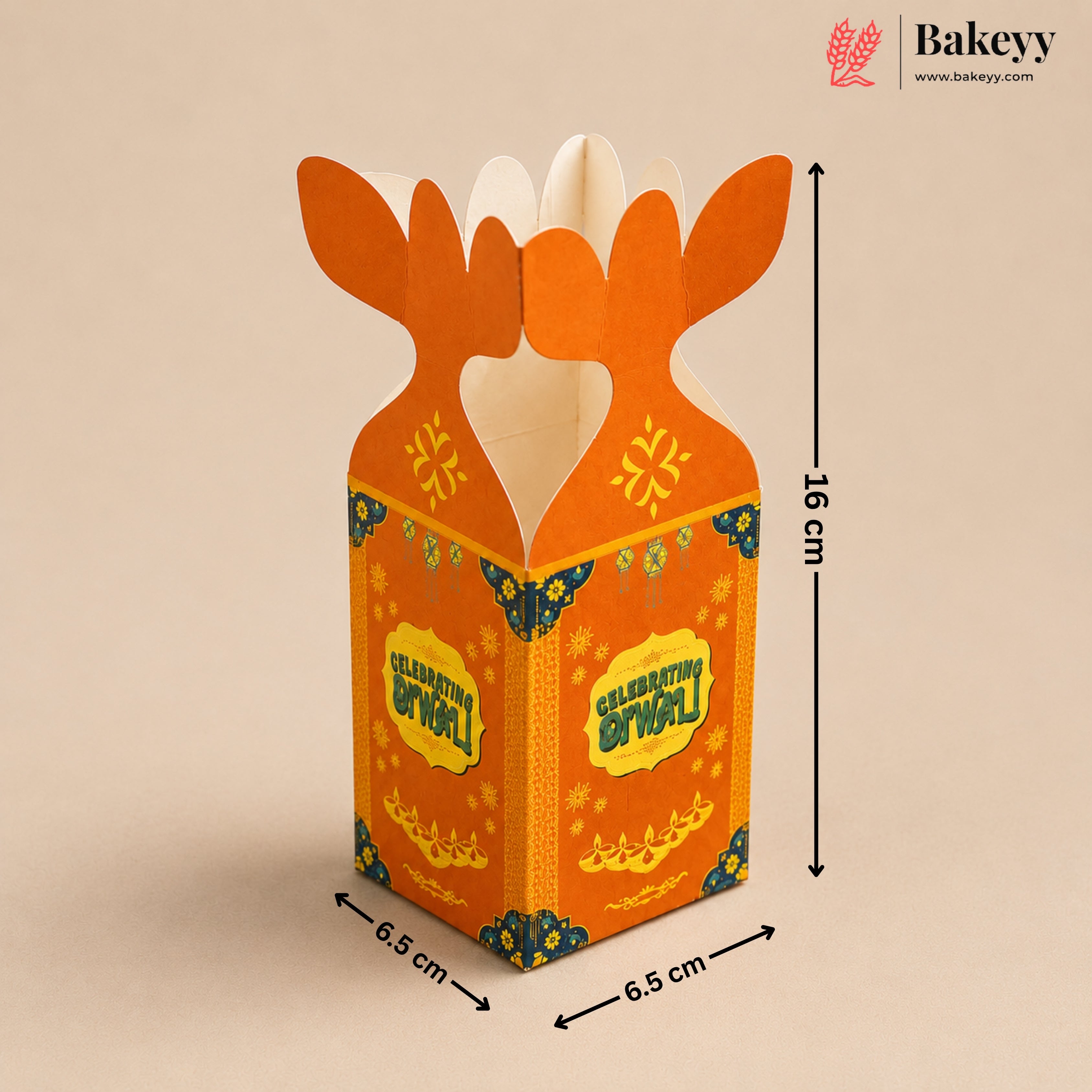 An orange cardboard gift box with a festive Golu design, featuring antler-like tabs at the top, decorated with yellow and blue patterns. The image includes dimension markings showing 16 cm height and 6.