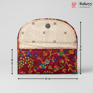 A fabric pouch or small bag shown front-facing on a light gray background, with dimension arrows and labels indicating 22 cm width, 20 cm height, and 10 cm depth. The product has a cream dotted upper section, a burgundy lower section, and multicolored floral embroidery with gold-toned thread.