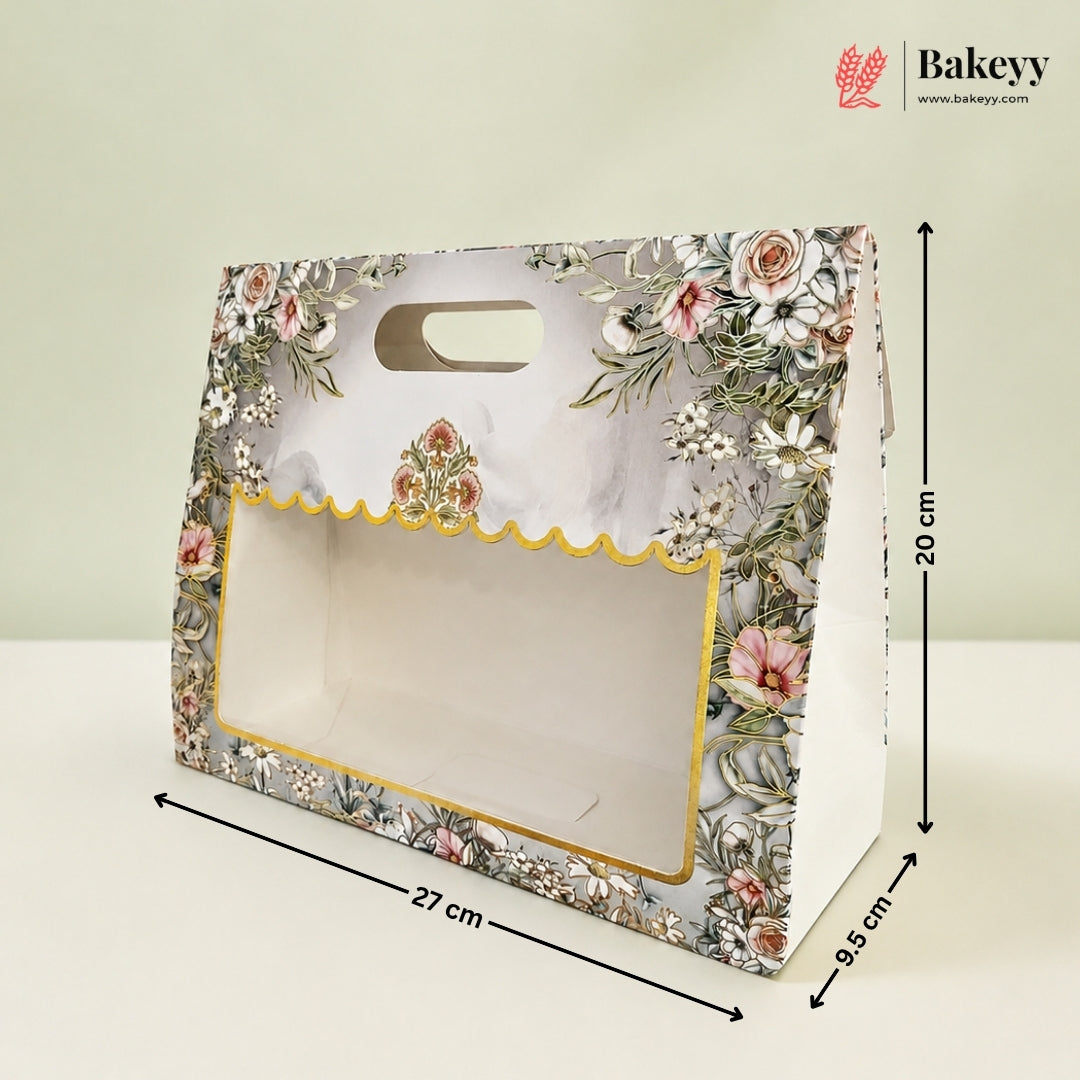 A floral bakery gift box with a clear window and scalloped gold trim, shown with dimension lines indicating 27 cm length, 20 cm height, and 9.5 cm width on a light background.
