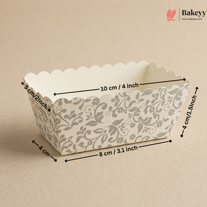 Decorative paper loaf pan with floral pattern and measurements on a beige background, featuring the Bakeyy brand.