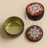 Decorative round container with floral design, open to reveal a green interior, on a beige background.