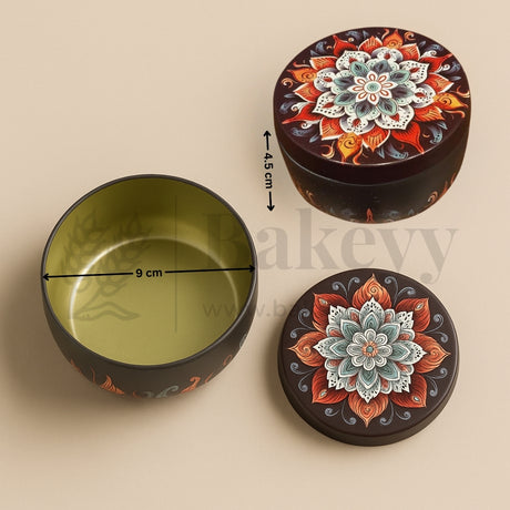 Decorative round container with floral design, open to reveal a green interior, on a beige background.