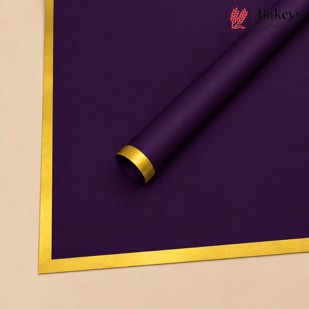 A roll of deep purple wrapping paper with a metallic gold border, shown on a light beige background. The Bakeyy logo is visible in the top right corner.