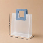 White paper bag with a blue handle and measurements on a beige background