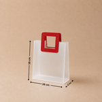 White paper bag with a red handle and measurements on a beige background