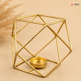 Gold geometric candle holder on a beige background