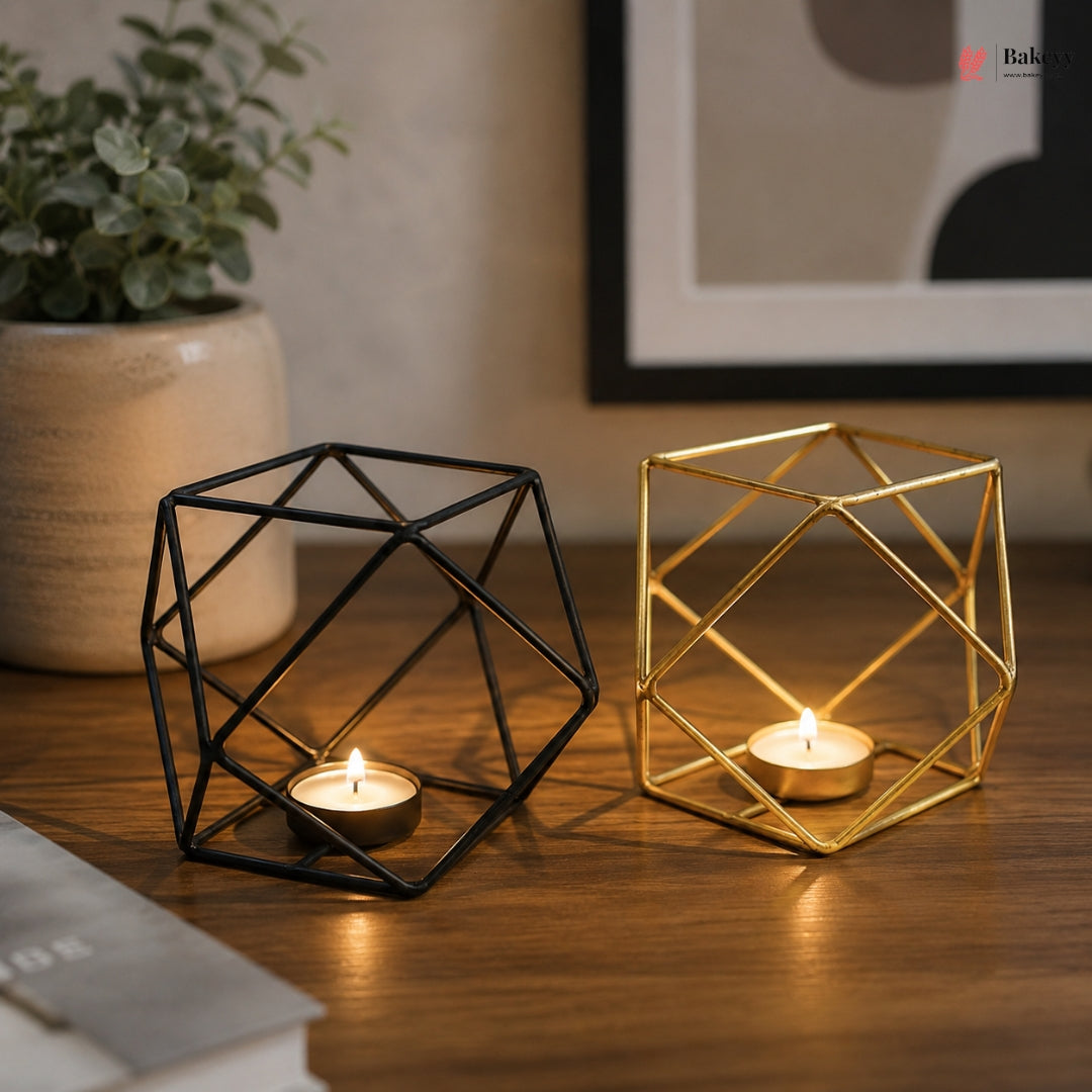 Geometric candle holders on a wooden surface with a plant and framed picture in the background.