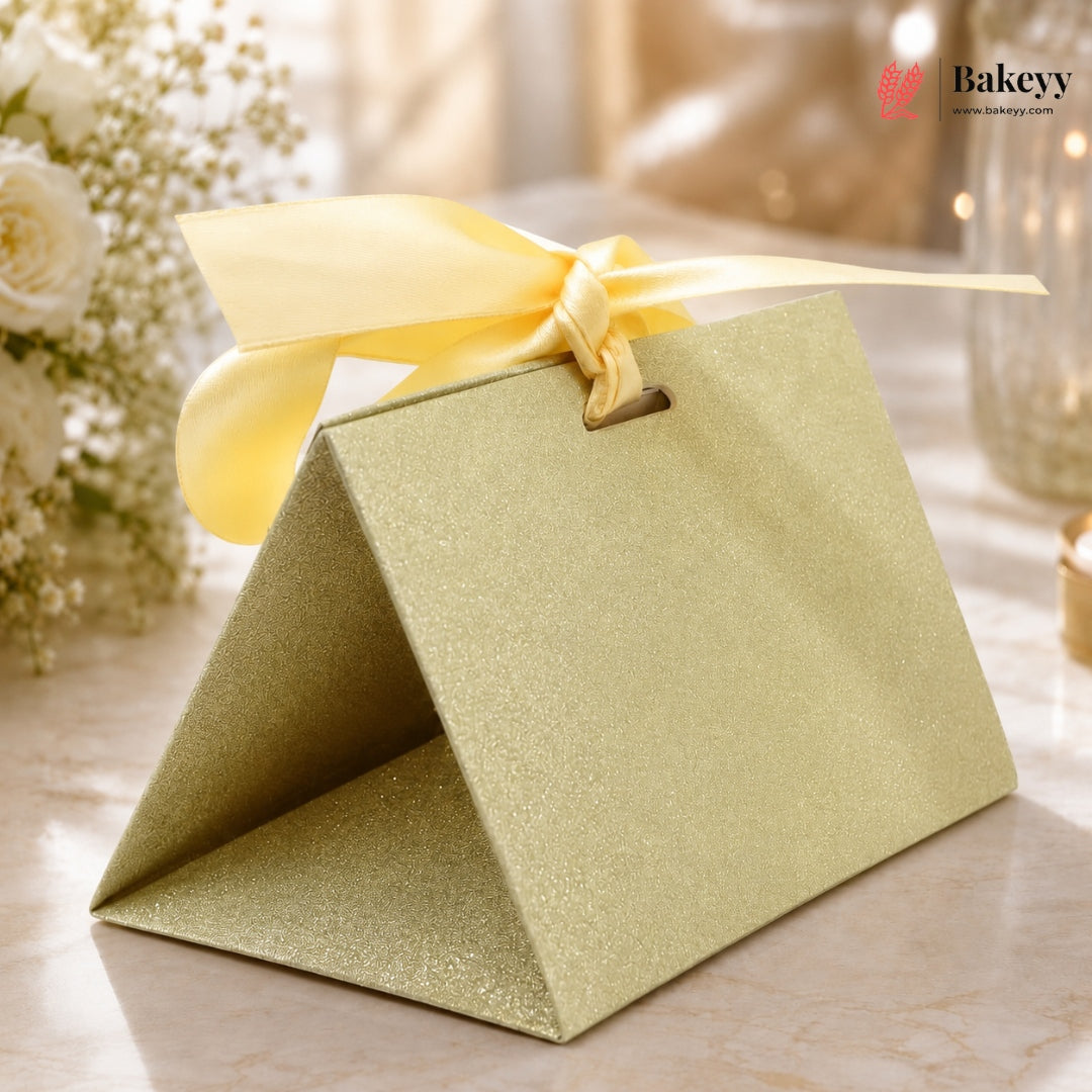 Green gift box with a yellow ribbon on a marble surface, with 'Bakeyy' branding.