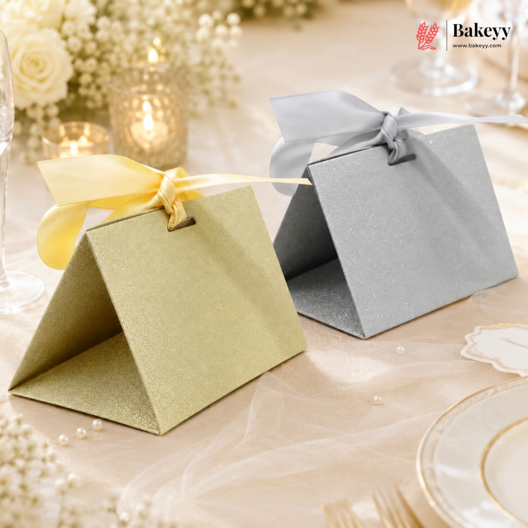 Two decorative boxes with ribbons on a table setting, featuring the Bakeyy brand.