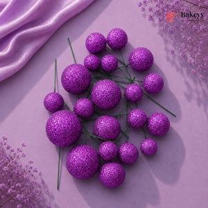 Purple glittery spherical flowers on a pink fabric background with 'Bakeyy' branding.
