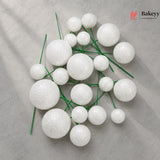 White spherical decorations on green stems with Bakeyy logo in the corner