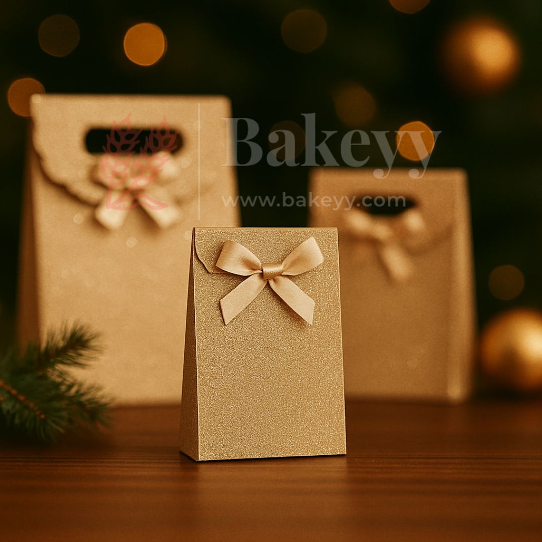 Gold gift box with a bow on a wooden surface with blurred lights in the background, featuring the brand 'Bakeyy'.