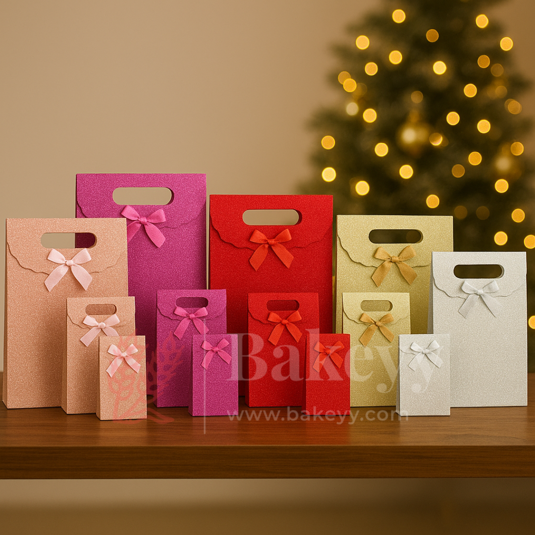 Colorful gift bags with ribbons on a wooden surface, Christmas tree in the background