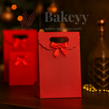 Red gift bag with a bow on a dark background, featuring the brand 'Bakeyy'.