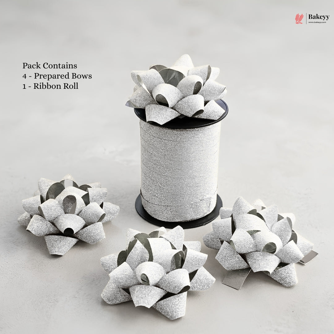 Bakey packaging with prepared bows and a ribbon roll on a light gray background
