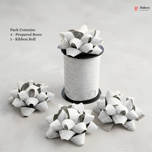 Bakey packaging with prepared bows and a ribbon roll on a light gray background