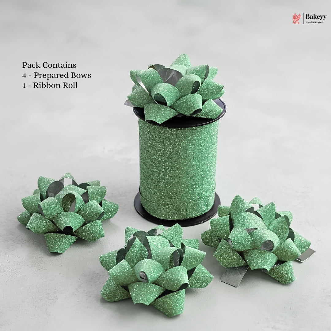 Green glittery bows and a roll of ribbon on a light gray background with 'Bakeyy' branding.