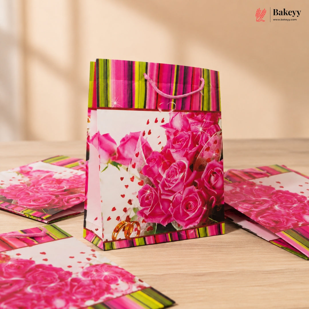 Gift bag with pink roses and colorful stripes on a wooden surface, with 'Bakeyy' branding.