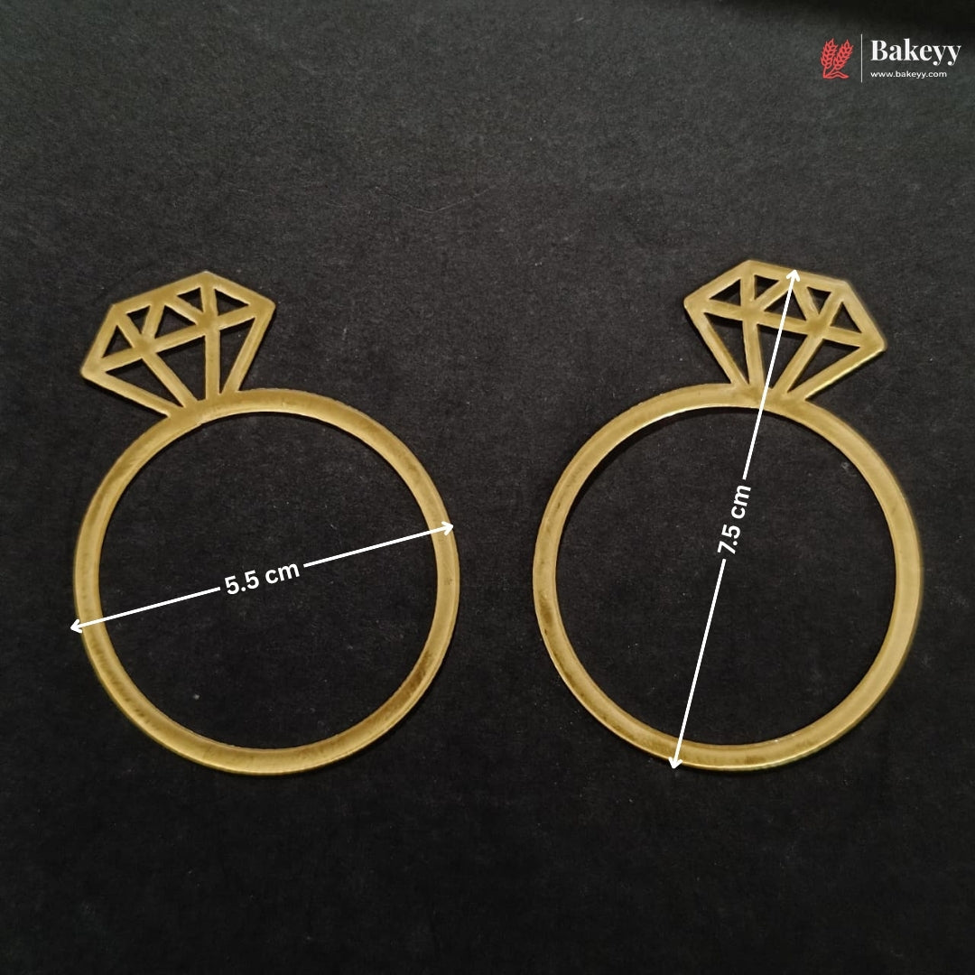 Two gold-colored ring-shaped baking molds with diamond designs on top, displayed on a black background with white dimension lines indicating 5.5 cm and 7.