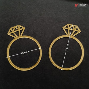 Two gold-colored ring-shaped baking molds with diamond designs on top, displayed on a black background with white dimension lines indicating 5.5 cm and 7.