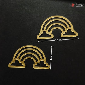Two gold rainbow-shaped baking molds or cutters on a black background, with white dimension arrows and text showing 7.5 cm width and 4 cm height.