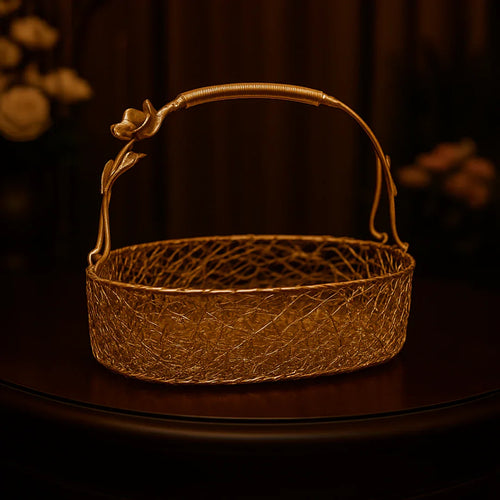 Gold metal hamper basket with floral handle on table, gift packaging by Bakeyy