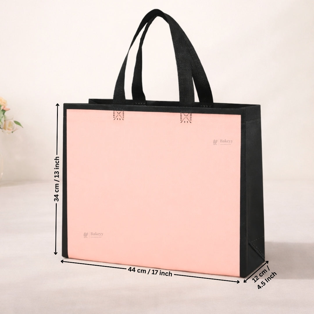 Pink tote bag with black handles and measurements on a light background