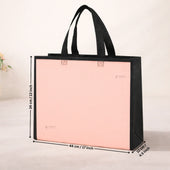Pink tote bag with black handles and measurements on a light background