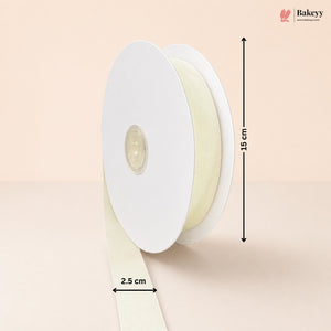 A spool of cream-colored ribbon on a light beige background, with dimension arrows and labels indicating a height of 15 cm and a width of 2.5 cm.