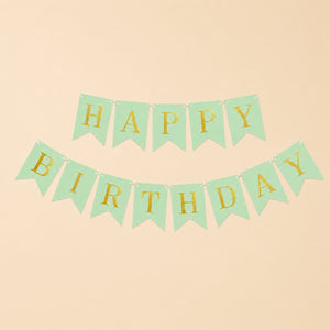 Green and gold 'Happy Birthday' banner on a beige background