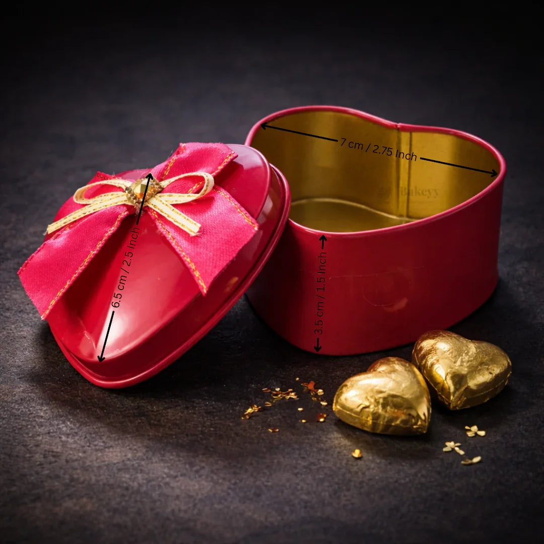 Red heart-shaped tin box with gold interior and bow, ideal for gift packaging from Bakeyy.com
