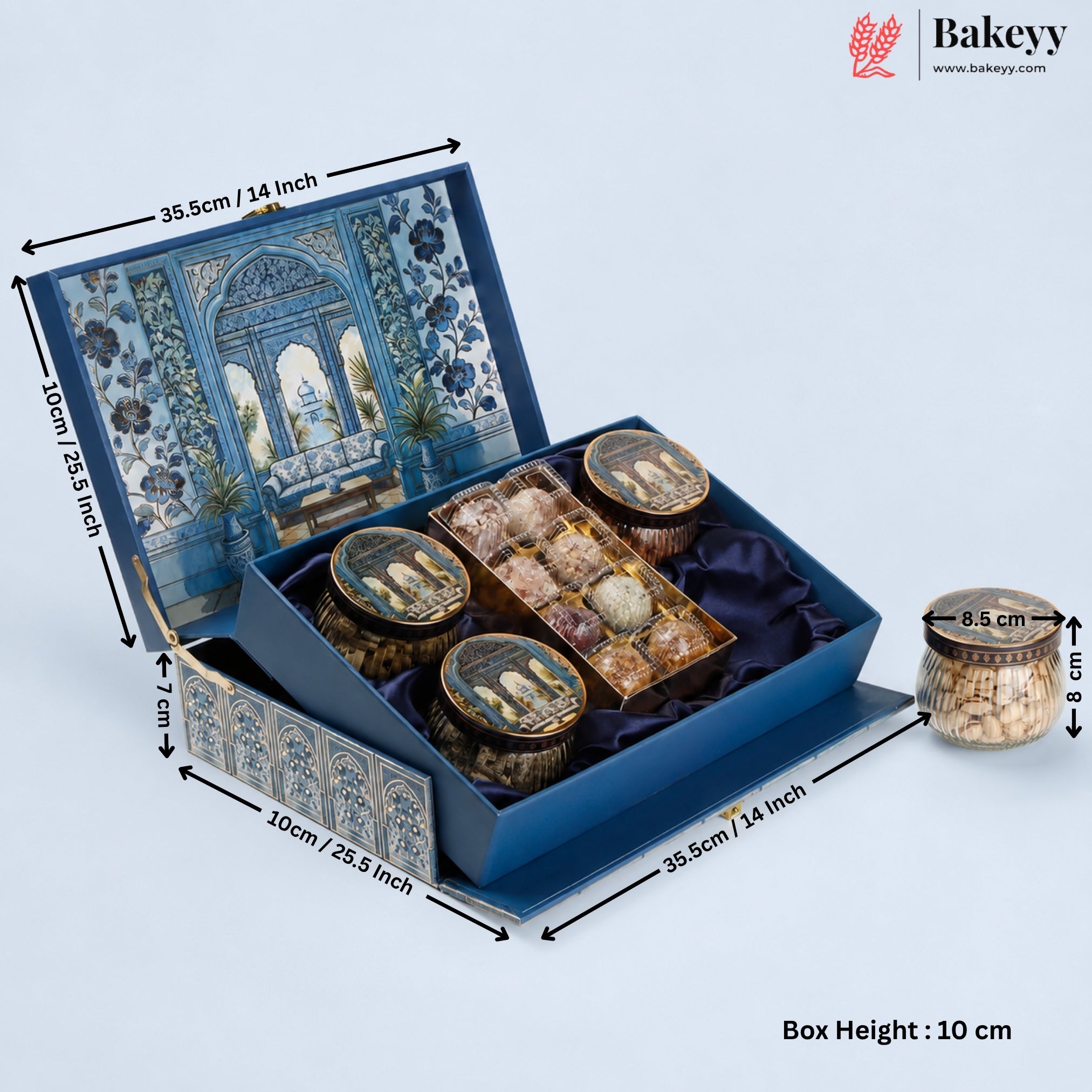 A blue decorative gift box for tea or snacks, shown open with dimension arrows and labels indicating measurements. The box has an illustrated blue-and-white architectural pattern on the lid and exterior, a dark blue satin interior, and several round tin containers with lids inside.
