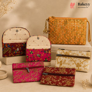 Six embroidered pouches and clutch bags in assorted floral and geometric patterns, displayed on beige blocks against a warm beige background. The Bakeyy brand logo is visible in the top right corner.